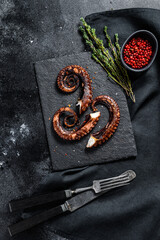 Grilled octopus tentacles. Fresh seafood. Black background. Top view