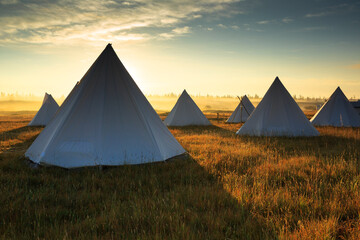 Scenic view of tents in field during sunrise