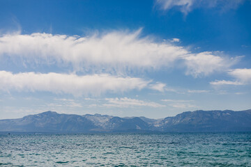 Clouds Across a Blue Sky with Mountains and a Lake