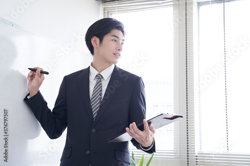 自信を持ってプレゼンをする日本人男性ビジネスマン Wall Mural Mapo