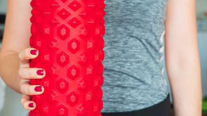 Woman holding the red foam roller.