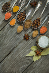 Fototapeta na wymiar Different spices, seasonings in spoons on a wooden background.