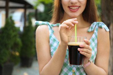 Young woman with cold kvass outdoors, closeup. Traditional Russian summer drink