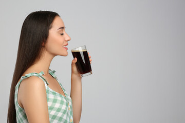 Beautiful woman with cold kvass on light grey background, space for text. Traditional Russian summer drink