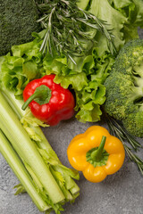Fresh vegetables-broccoli, celery, sweet pepper, lettuce on a gray concrete background