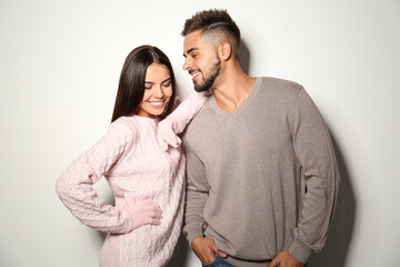 Naklejka premium Lovely couple in warm sweaters on light background