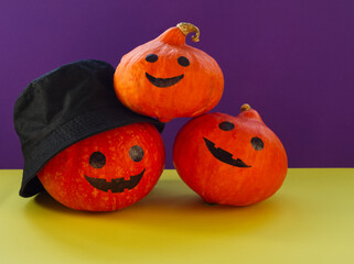 Set of orange pumpkin on black background. Halloween holiday. Orange Hokkaido pumpkin with smile and eyes, one pumpkin with black bucket hut. Holiday decoration