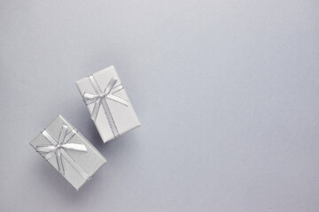 A pair of grey gift boxes are insulated on grey.