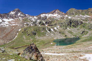 Hiking trail in Aosta valley, Cogne, Italy. View of the alpine basin of the first lake of Lussert. Photo taken at an altitude of 2700 meters.