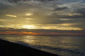 Beautiful orange sunset above the sea, below the cloudy sky, Japan