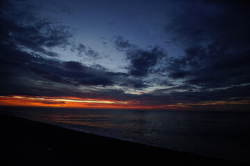 Beautiful orange sunset above the sea, below the cloudy sky, Japan