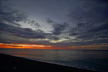 Beautiful orange sunset above the sea, below the cloudy sky, Japan