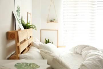 Stylish room interior with bed and floral pictures