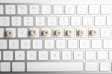 Beads with word KEYWORDS on keyboard, flat lay