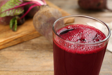 Freshly made beet juice in glass on wooden table, closeup