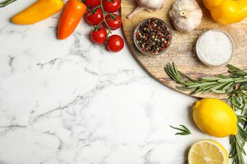 Flat lay composition with ingredients for cooking on white marble table. Space for text