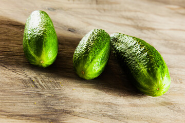 Cucumber on the grey wood textured background, fresh vegetables, summer in the garden.