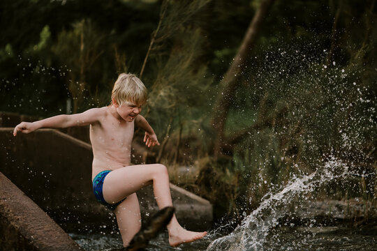 Boy Swimming In Natural Swimming Hole Causing Splash Kicking Water In Central New South Wales, Australia