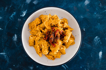 plant-based food, vegan maccheroni pasta with hummus based sauce and sundried tomatoes