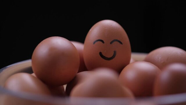 Rack focus to egg with smiley face, static close up.