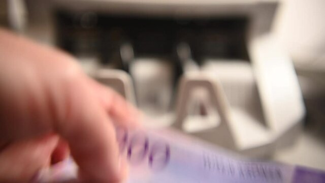 Close View Of Man Counting Stack Of One Thousand Norwegian Krone Banknotes in His Hands.