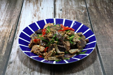 Traditional fried and stirred chopped duck meat and duck offal with chilly, basil and local sauce on the plate. Famous hot and spicy duck meat in Asia restaurant. 