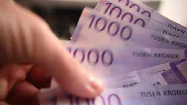 Male Holding Few Banknotes In Hand. Norwegian Thousand Krone Bills Fanned Out And Counted By Man In Close View. 