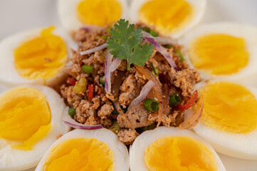 Half boiled egg and Pork Larb on a plate