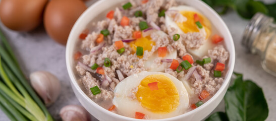 Boiled egg porridge in white bowl.
