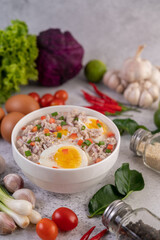 Boiled egg porridge in white bowl.