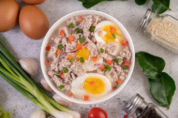 Boiled egg porridge in white bowl.