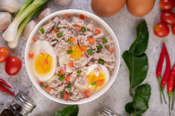 Boiled egg porridge in white bowl.