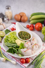 Squid stuffed with cooked pork with seafood sauce.