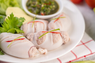 Squid stuffed with cooked pork with seafood sauce.