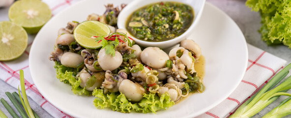 Spicy Squid Salad with White Platter with Spring Onion, Chili, Lime and Tomato.