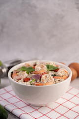 Shrimp Salad with Tomato Red onion and coriander in a white cup.