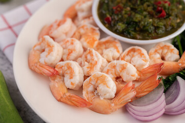 The cooked prawns are arranged in a plate with dipping sauce.