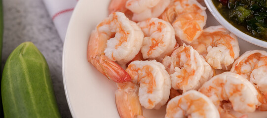 The cooked prawns are arranged in a plate with dipping sauce.