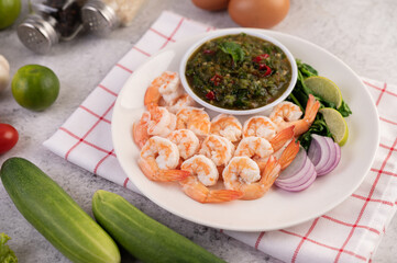 The cooked prawns are arranged in a plate with dipping sauce.