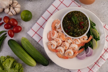 The cooked prawns are arranged in a plate with dipping sauce.