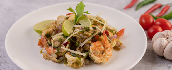Shrimp cooked with lemongrass, vegetables, lime and chili on a white plate