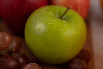 Apples and grapes put together on the ground.