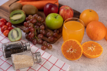 Orange cut in half with grapes and orange juice.