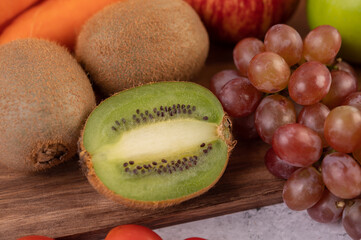 Kiwi, grapes, apples, carrots, and tomatoes.