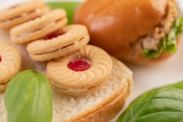Bread slices, stuffed buns, and burgers on a white plate.