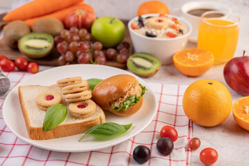 Bread slices, stuffed buns, and burgers on a white plate.