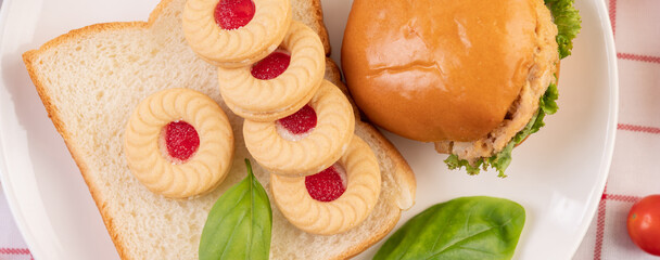 Bread slices, stuffed buns, and burgers on a white plate.