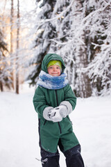Fototapeta na wymiar Portrait of a cute little boy in warm clothes who play with snowflakes in winter sunny frosty day, beautiful seasonal card, Siberia nature, kids play, having fun in wonderland forest