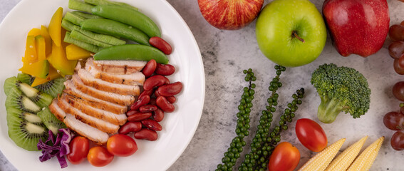 Sliced ​​chicken steak with peas, tomatoes, kiwi and pumpkin.