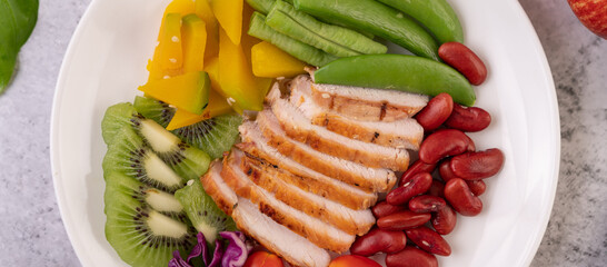 Sliced ​​chicken steak with peas, tomatoes, kiwi and pumpkin.